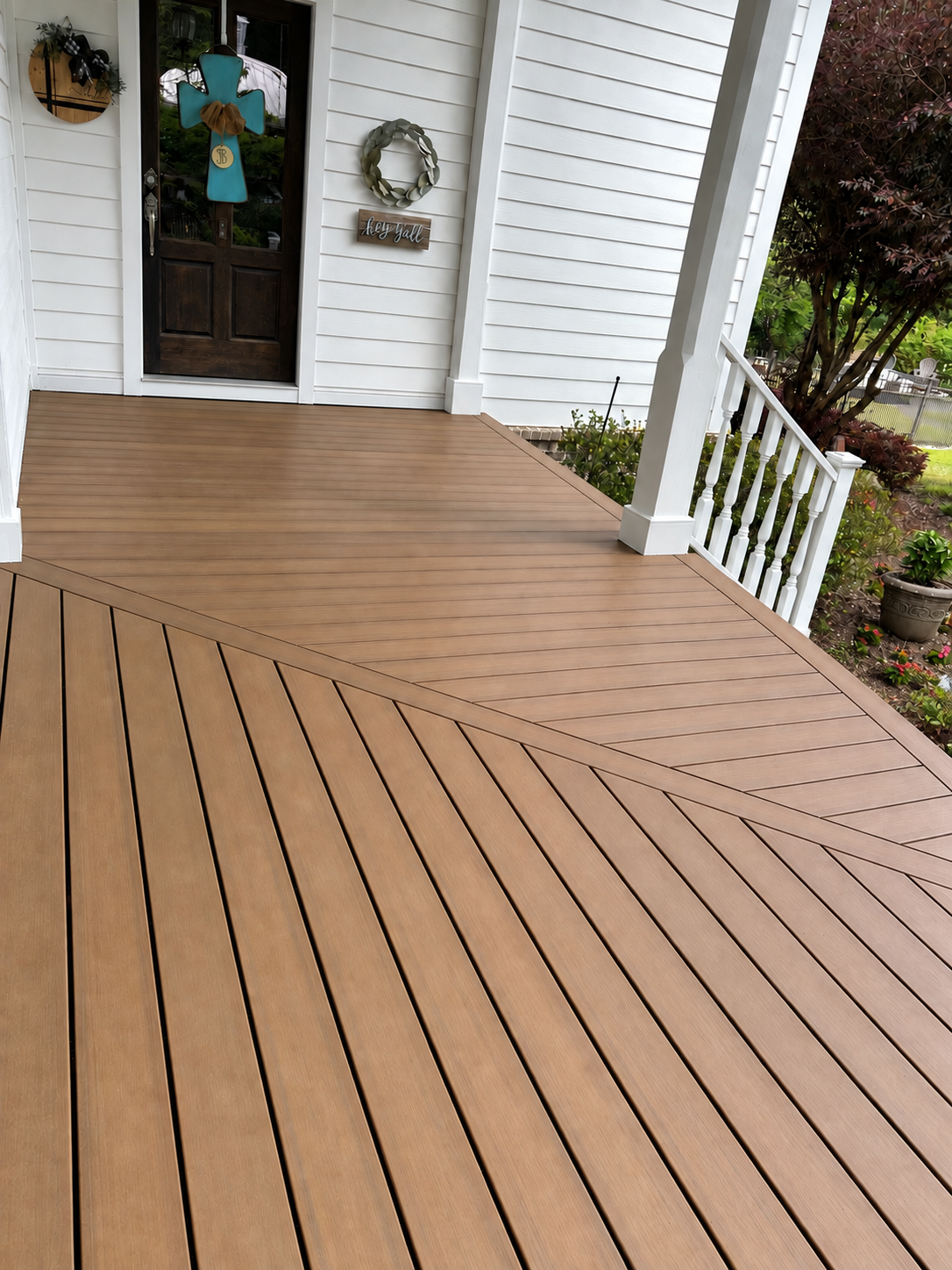 Finished composite entry deck with clean post bases, exterior trim, and carefully framed diagonal inlay pattern